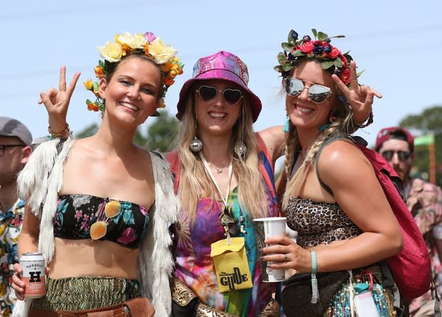Festival goers in the hot weather on the third day of the Glastonbury Festival at Worthy Farm in Somerset