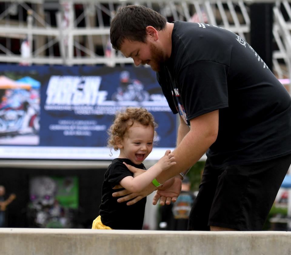 Jeff Kopache of Canton enjoys playtime with son Jameson, 2, on June 24 during the second annual Canton Ride-In Tailgate event at Canton Centennial Plaza with all proceeds going to Save22, a veteran organization to help prevent veteran suicide.
