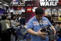 Customers pick new toys from the upcoming film "Star Wars: The Force Awakens" on "Force Friday" in Hong Kong, China, September 4, 2015. REUTERS/Tyrone Siu