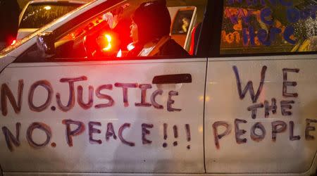 A protester, demanding the criminal indictment of a white police officer who shot dead an unarmed black teenager in August, sits in her vehicle outside the Ferguson Police Department in Missouri November 21, 2014. REUTERS/Adrees Latif