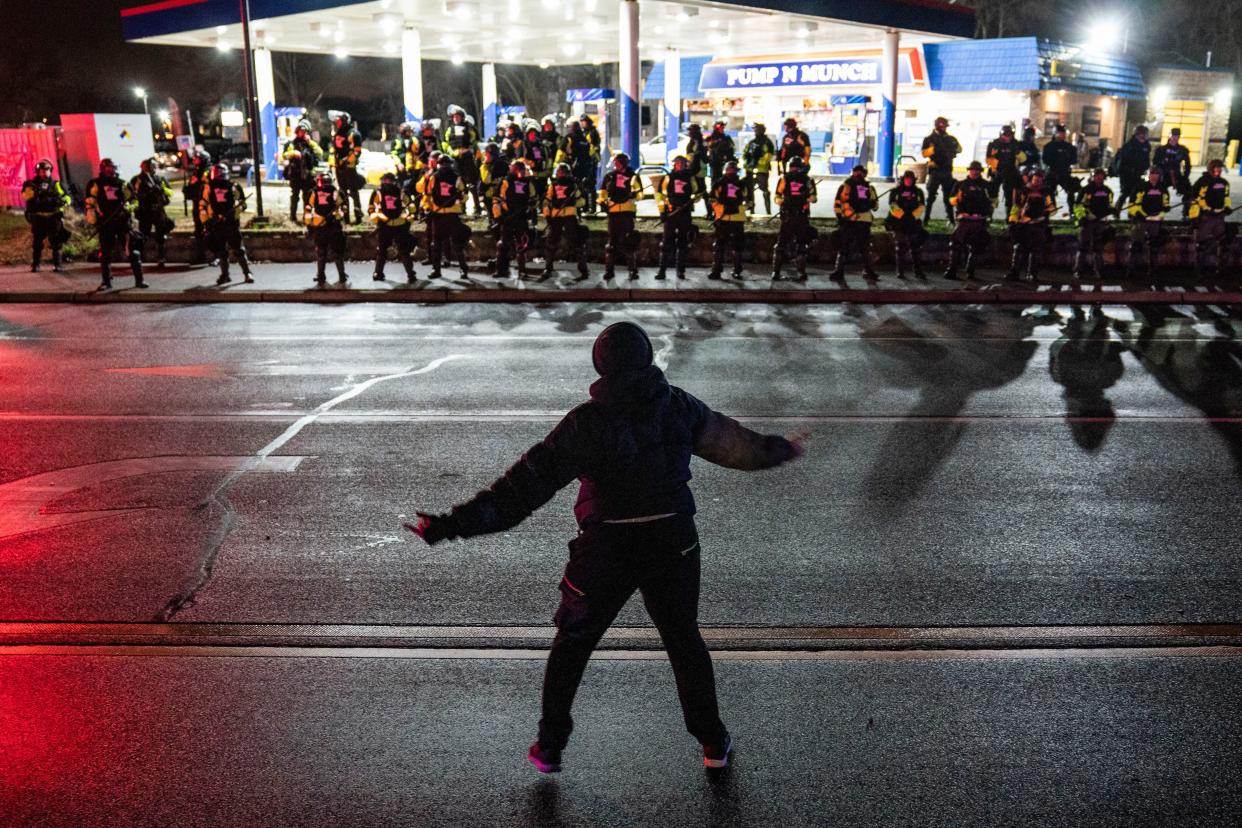 A demonstrator confronts authorities who advanced into a gas station after issuing orders for crowds to disperse during a protest against the police shooting of Daunte Wright, late Monday, April 12, 2021, in Brooklyn Center, Minn.
