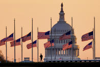 Lowered to half-staff in honor of former Senate Majority Leader Bob Dole of Kansas, flags fly in the breeze at sunrise on the National Mall with the U.S. Capitol in the background, Monday, Dec. 6, 2021, in Washington. (AP Photo/J. David Ake)