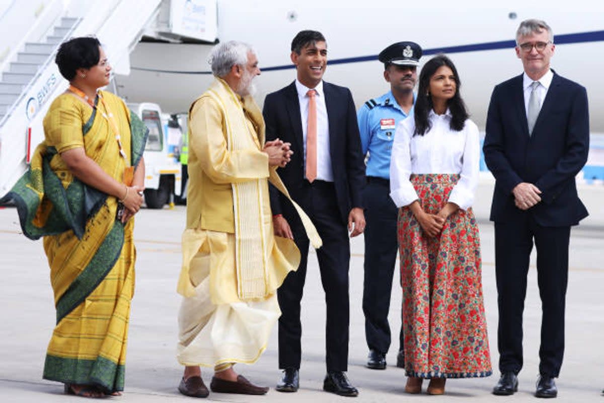 UK Prime Minister Rishi Sunak and his wife Akshata Murty (C) are met on the tarmac by dignitaries including the Indian Minister of State (Getty Images)