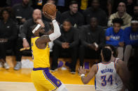 Los Angeles Lakers forward LeBron James, left, scores to pass Kareem Abdul-Jabbar to become the NBA's all-time leading scorer as Oklahoma City Thunder guard Josh Giddey, right, and forward Kenrich Williams defend during the second half of an NBA basketball game Tuesday, Feb. 7, 2023, in Los Angeles. (AP Photo/Marcio Jose Sanchez)