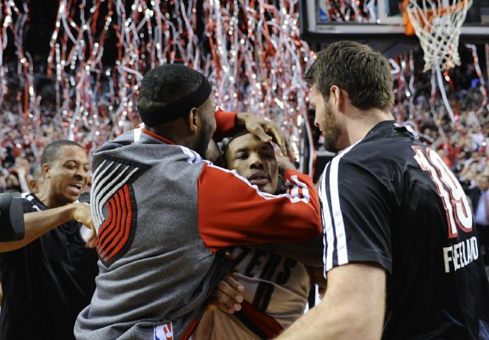 Portland Trail Blazers' Damian Lillard, center, celebrates his winning shot against the Houston Rockets during the last .9 of a second of game six of an NBA basketball first-round playoff series game in Portland, Ore., Friday May 2, 2014. The Trail Blazers won the series in a 99-98 win. (AP Photo/Greg Wahl-Stephens)