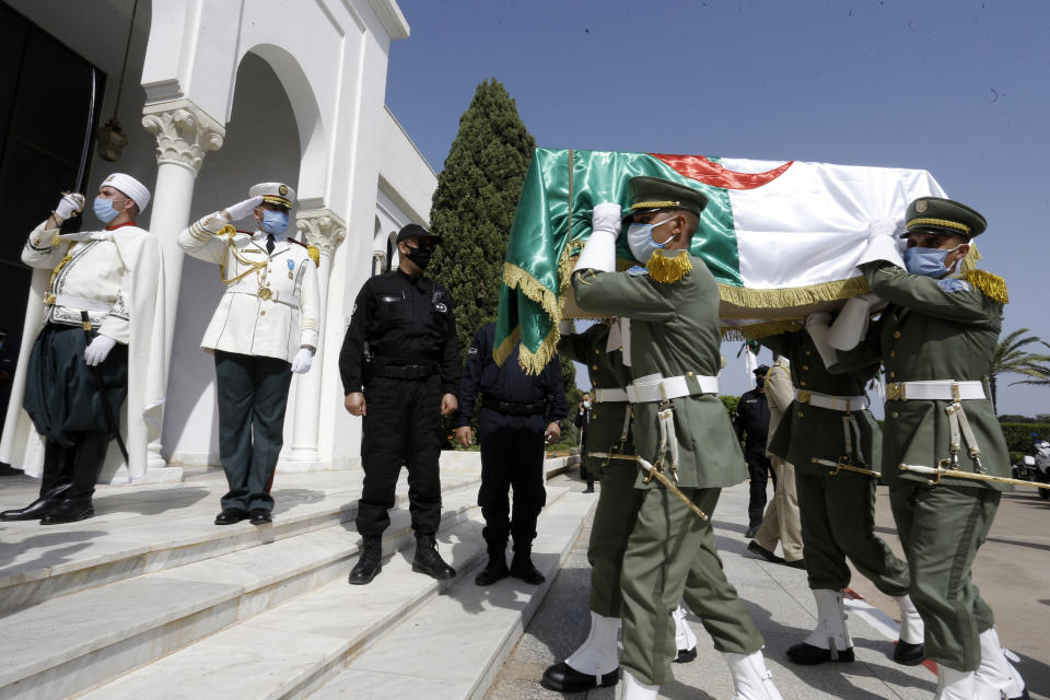 The remains of 24 Algerians are carried by members of the Algerian Republican Guard at the Moufdi-Zakaria culture palace in Algiers, Friday, July, 3, 2020. After decades in a French museum, the skulls of 24 Algerians decapitated for resisting French colonial forces were formally repatriated to Algeria in an elaborate ceremony led by the teary-eyed Algerian president. The return of the skulls was the result of years of efforts by Algerian historians, and comes amid a growing global reckoning with the legacy of colonialism. (AP Photo/Toufik Doudou)