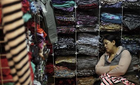 A Bolivian immigrant rests as she waits for customers inside her shop in the Bras neighbourhood of Sao Paulo early morning August 9, 2013. REUTERS/Nacho Doce