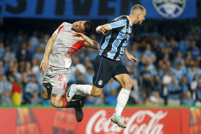 El defensa de Estudiantes de Argentina Zaid Romero y el defensa de Gremio de Brasil Rodrigo Ely luchan por el balón durante el partido de fútbol de vuelta de la fase de grupos de la Copa Libertadores, en el estadio Couto Pereira de Curitiba, Brasil, el 8 de junio de 2024. (Albari Rosa)