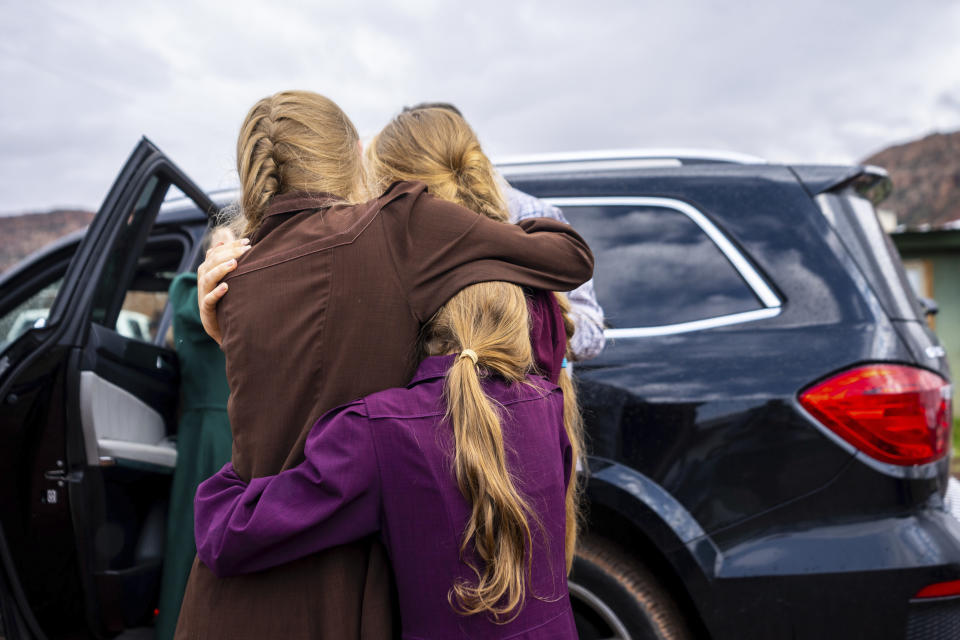 FILE - Family and followers of polygamous sect leader Samuel Bateman gather around as he calls from police custody following his arrest in Colorado City, Ariz., Sept. 13, 2022. Prosecutors have widened their case against the leader of a small polygamous group that resides near the Utah-Arizona border, adding child pornography charges and detailing Bateman's sexual encounters with children he took as wives in new charges filed earlier in May 2023. (Trent Nelson/The Salt Lake Tribune via AP, File)