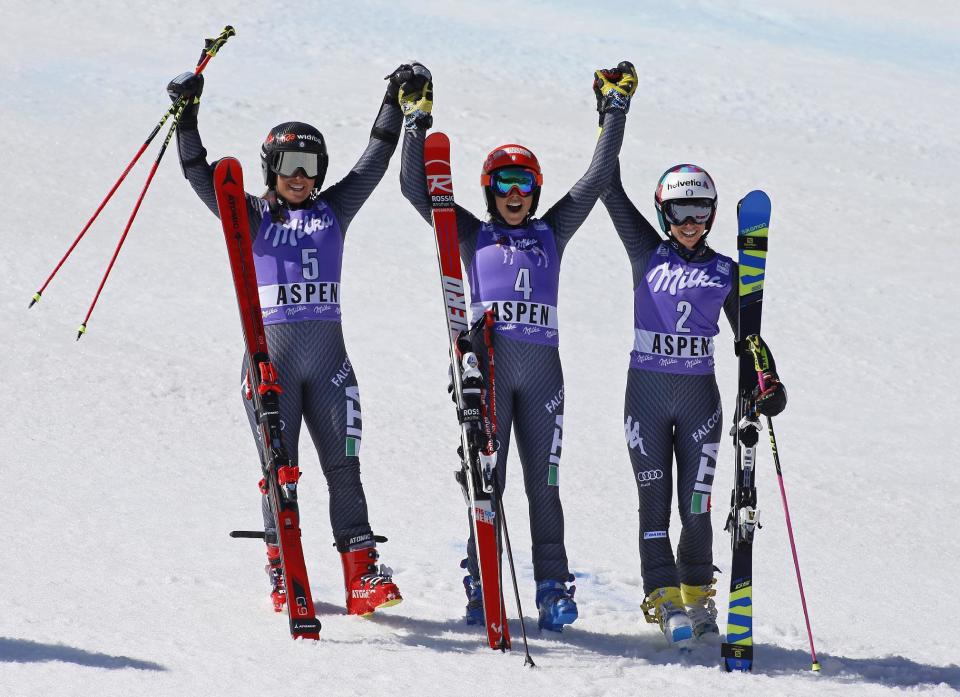 First place finisher Italy's Federica Brignone, center, celebrates with second place finisher Italy's Sofia Goggia, left, and third place finisher Italy's Marta Bassino after the second run of a women's World Cup giant slalom ski race Sunday, March 19, 2017, in Aspen, Colo. (AP Photo/Nathan Bilow)