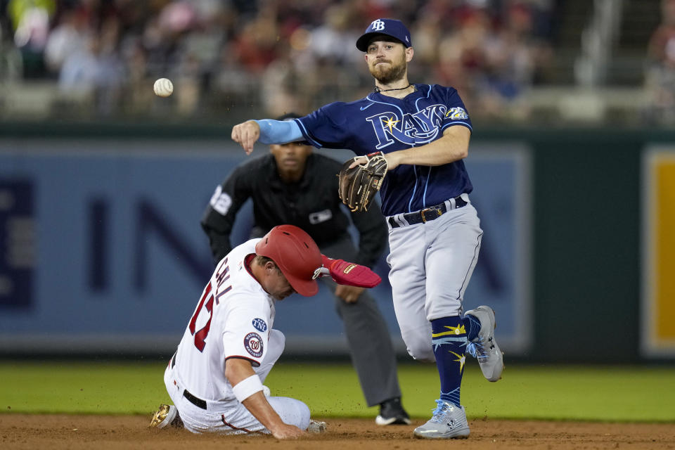 Washington Nationals' Alex Call, left, is out as Tampa Bay Rays second baseman Brandon Lowe throws to first base for the double play during the third inning of a baseball game at Nationals Park, Tuesday, April 4, 2023, in Washington. (AP Photo/Alex Brandon)