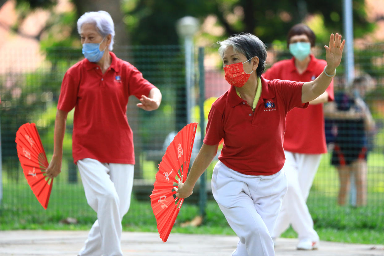 People wearing protective masks exercise at a park during the COVID-19 pandemic in Singapore. (PHOTO: NurPhoto via Getty Images)