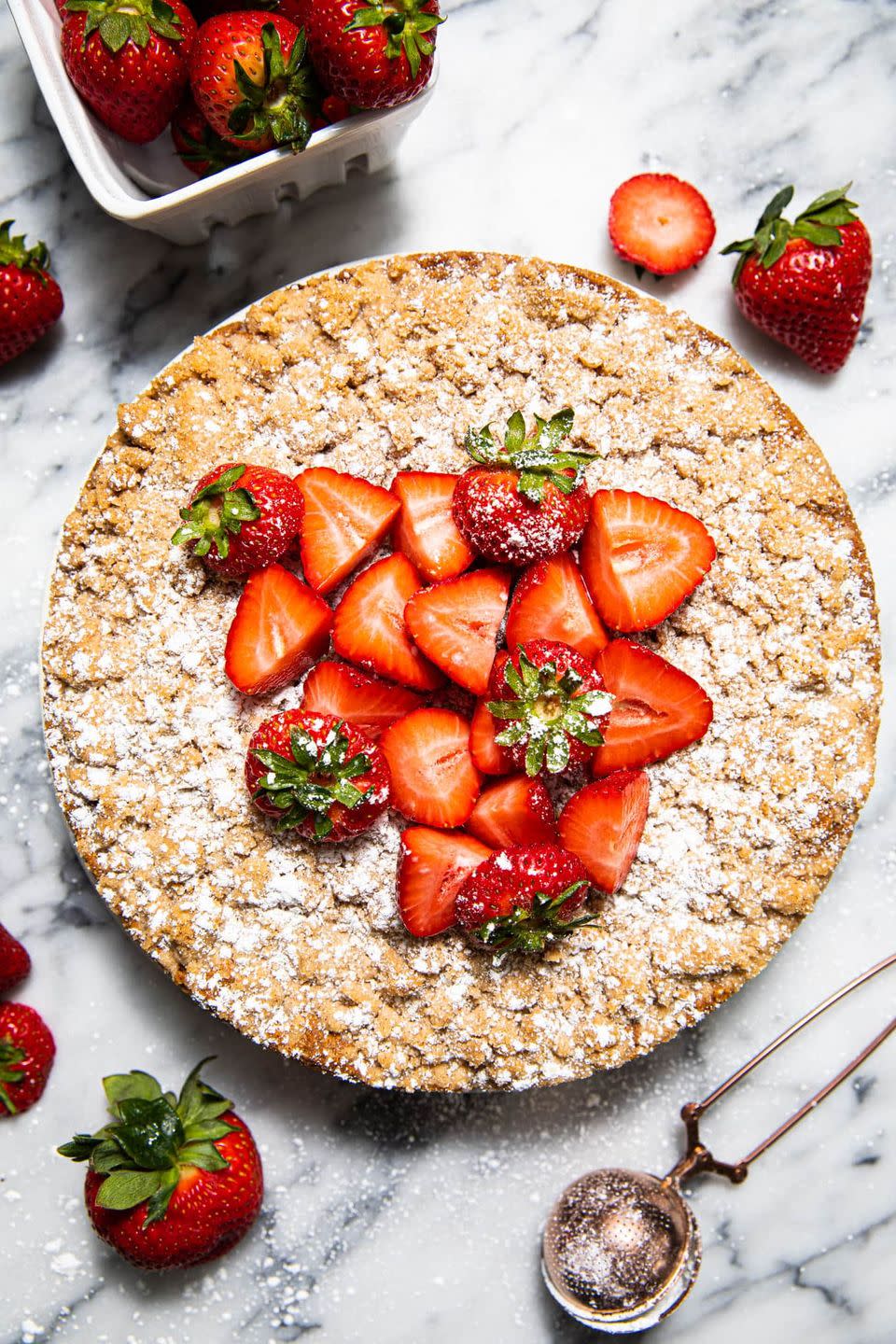 strawberry crumb cake with fresh strawberries on top and scooper