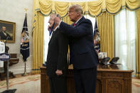 President Donald Trump presents the Presidential Medal of Freedom to former football coach Lou Holtz, in the Oval Office of the White House, Thursday, Dec. 3, 2020, in Washington. (AP Photo/Evan Vucci)