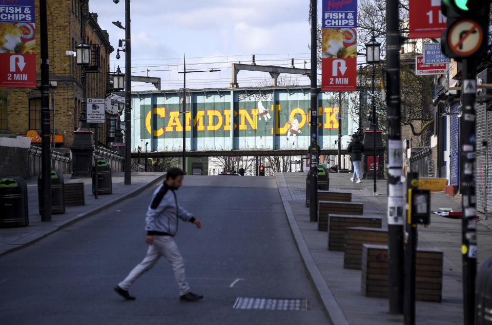 A man walks in an empty Camden High Street, due to the Coronavirus outbreak, in London, Sunday, March 29, 2020. The public have been asked to self isolate, keeping distant from others to limit the spread of the contagious COVID-19 coronavirus. The new coronavirus causes mild or moderate symptoms for most people, but for some, especially older adults and people with existing health problems, it can cause more severe illness or death. (AP Photo/Alberto Pezzali)