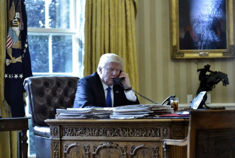 US President Donald Trump speaks on the phone with Russia's President Vladimir Putin from the Oval Office of the White House on January 28, 2017, in Washington, DC