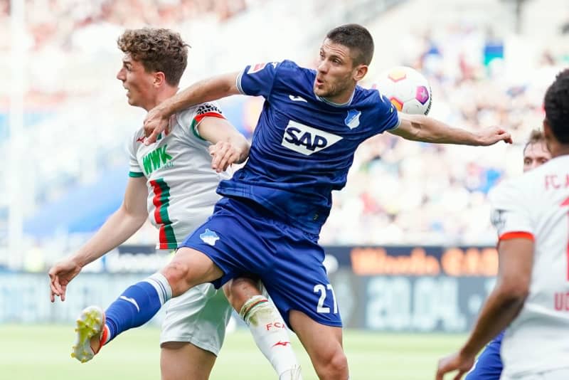 Hoffenheim's Andrej Kramaric (R) and Augsburg's Arne Engels battle for the ball during the German Bundesliga soccer match between TSG 1899 Hoffenheim and FC Augsburg at the PreZero Arena. Uwe Anspach/dpa