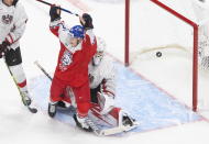 Czech Republic's Pavel Novak (13) reacts as the puck goes in past Austria goalie Sebastian Wraneschitz (1) during second-period IIHF World Junior Hockey Championship action in Edmonton, Alberta, Thursday, Dec. 31, 2020. (Jason Franson/The Canadian Press via AP)