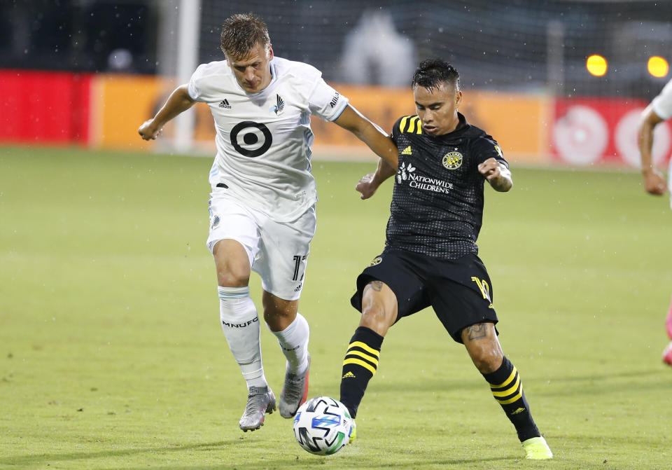 Minnesota United midfielder Robin Lod (17) and Columbus Crew midfielder Lucas Zelarrayan (10) battle for the ball during the first half of an MLS soccer match in Kissimmee, Fla., Tuesday, July 28, 2020. (AP Photo/Reinhold Matay)