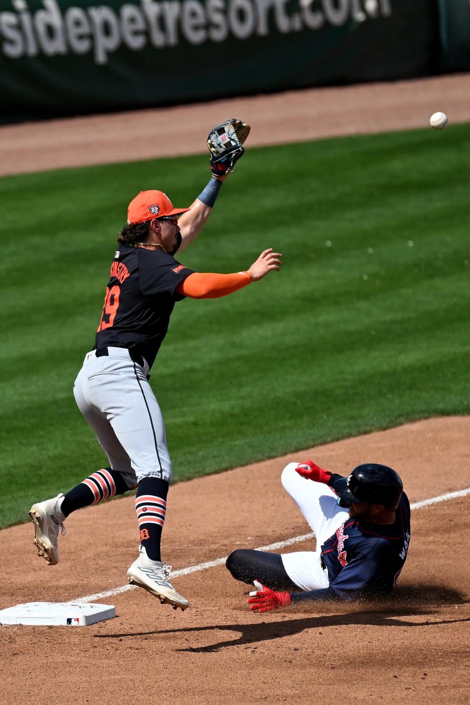 Atlanta Braves left fielder Forrest Wall slides into third base as Detroit Tigers third baseman Zach McKinstry (39) leaps to make the catch in the third inning of the spring training game at CoolToday Park on March 5, 2024, in North Port, Florida.