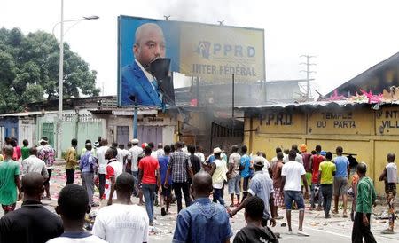 Congolese opposition supporters chant slogans as they destroy the billboard of President Joseph Kabila during a march to press the President to step down in the Democratic Republic of Congo's capital Kinshasa. REUTERS/Kenny Katombe