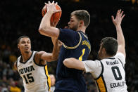 Michigan center Hunter Dickinson (1) drives between Iowa forward Keegan Murray (15) and forward Filip Rebraca (0) during the first half of an NCAA college basketball game, Thursday, Feb. 17, 2022, in Iowa City, Iowa. (AP Photo/Charlie Neibergall)