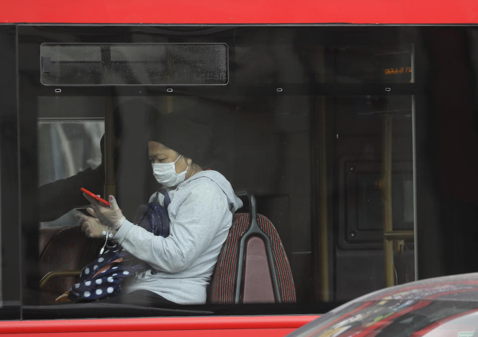 A bus passenger wears a mask as she travels in London, Friday, June 5, 2020. It will become compulsory to wear face coverings whilst using public transport in England from Monday June 15. (AP Photo/Kirsty Wigglesworth)