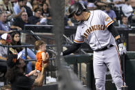 San Francisco Giants' Wilmer Flores, right, gives a young fan a greeting during the seventh inning of the team's baseball game against the Arizona Diamondbacks, Friday, Sept. 23, 2022, in Phoenix. (AP Photo/Rick Scuteri)