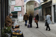 People wearing face masks queue to enter a bakery in Lisbon, Monday, Nov. 29, 2021. Portuguese health authorities on Monday identified 13 cases of omicron, the new coronavirus variant spreading fast globally, among members of the Lisbon-based Belenenses SAD soccer club, and were investigating possible local transmission of the virus outside of southern Africa. (AP Photo/Ana Brigida)