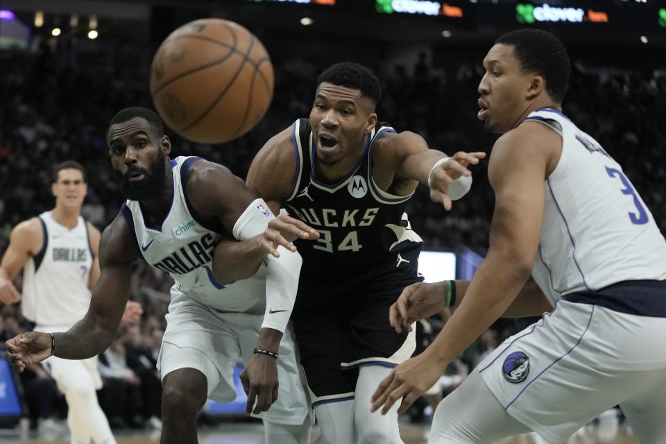 Milwaukee Bucks' Giannis Antetokounmpo goes after a loose ball with Dallas Mavericks' Grant Williams and Tim Hardaway Jr. during the second half of an NBA basketball game Saturday, Nov. 18, 2023, in Milwaukee. The Bucks won 132-125. (AP Photo/Morry Gash)