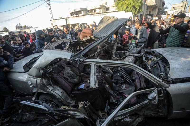People gather to inspect the remains of a vehicle destroyed by reported Israeli bombardment in Rafah in the southern Gaza Strip on Tuesday. Photo by Ismael Mohamad/UPI