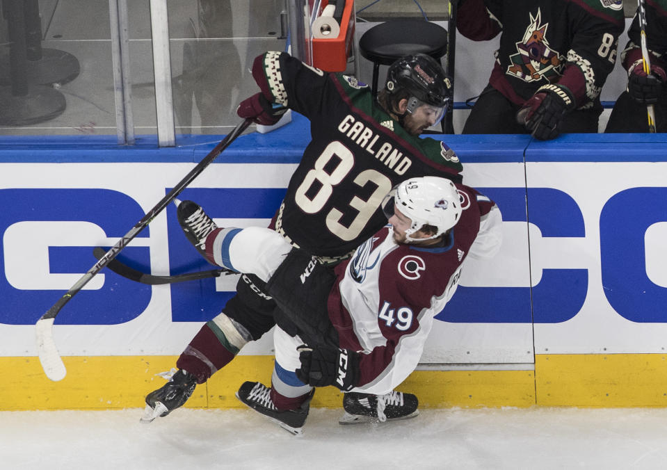 Colorado Avalanche's Samuel Girard (49) is checked by Arizona Coyotes' Conor Garland (83) during the first period in Game 4 of an NHL hockey first-round playoff series in Edmonton, Alberta, Monday, Aug. 17, 2020. (Jason Franson/The Canadian Press via AP)