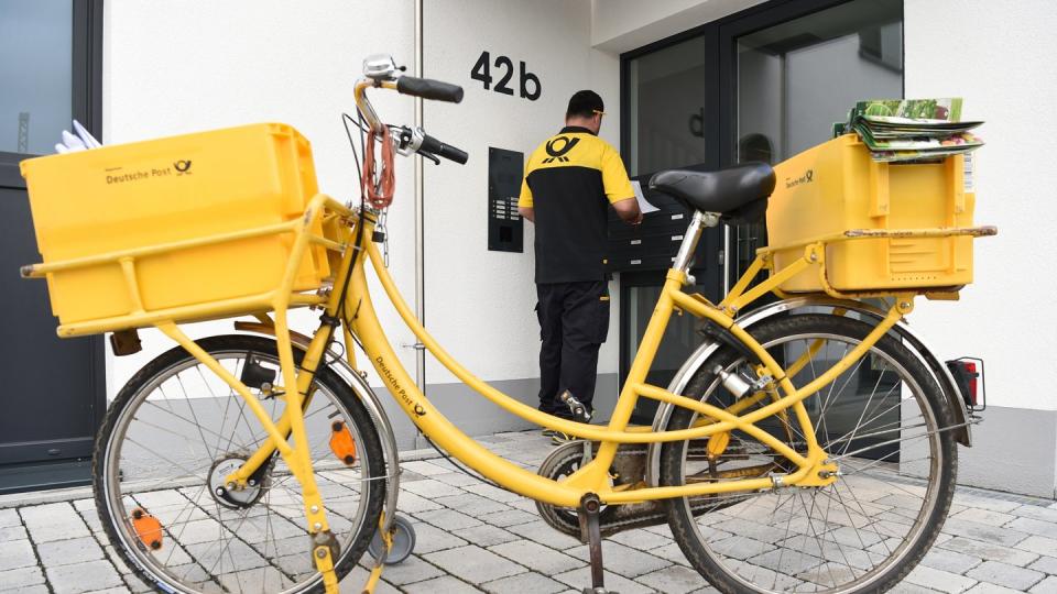 Ein Briefträger der Deutschen Post verrichtet in Frankfurt am Main seine Arbeit. Foto: Arne Dedert