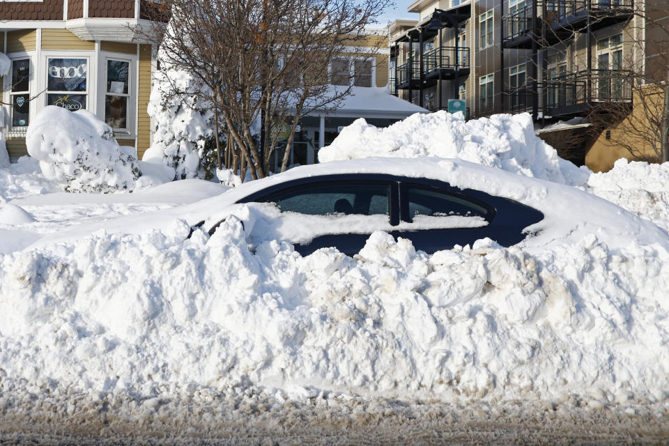 A car sits buried under snow, Wednesday, Dec. 28, 2022, in Buffalo N.Y., following a winter storm. (AP Photo/Jeffrey T. Barnes)