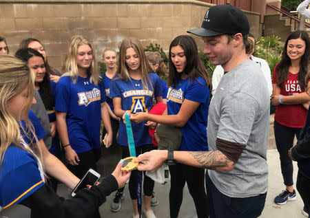 U.S. Olympic freestyle skier David Wise shows off one of his two gold medals to students from Agoura High School, in Agoura Hills, California, U.S., December 17, 2018. REUTERS/Rory Carroll