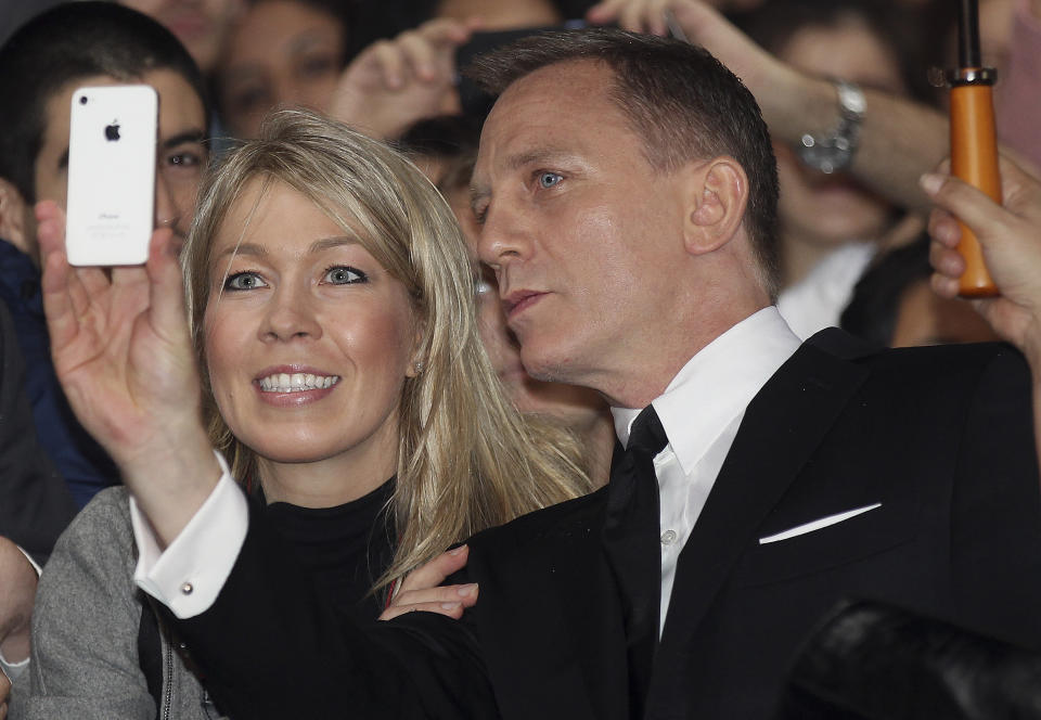 FILE - This is a Nov. 16, 2012 file photo of actor Daniel Craig as he takes a photo with a fan in the crowd during the premier of the latest James Bond film, "Skyfall" in Sydney, Australia. A former tabloid reporter who admits illegally snooping on voicemails says he "routinely" hacked the phone of actor Daniel Craig. Dan Evans has pleaded guilty to phone hacking while at the News of the World and the Sunday Mirror. He is a prosecution witness at the trial in London of former News of the World editors Andy Coulson and Rebekah Brooks, and five others. He told the jury on Thursday Jan. 30, 2014 "I was routinely hacking Daniel Craig's phone from my Sunday Mirror days." He said he obtained a story about supermodel Kate Moss from Craig's voicemail messages. (AP Photo/Rob Griffith, File)