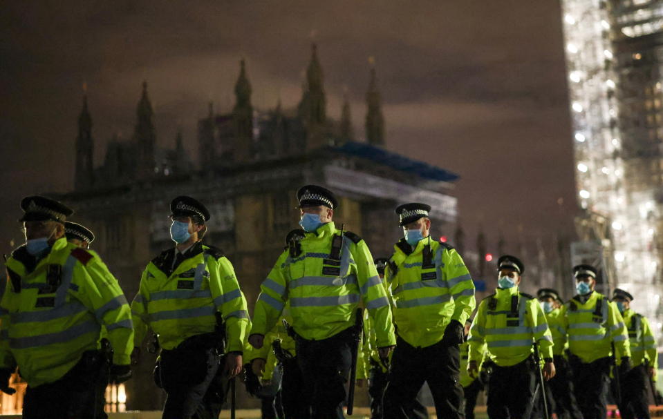 Police officers cross Westminster Bridge in front of the Houses of Parliament during the protest.