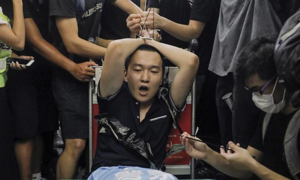 Man on trolley with hands in luggage ties