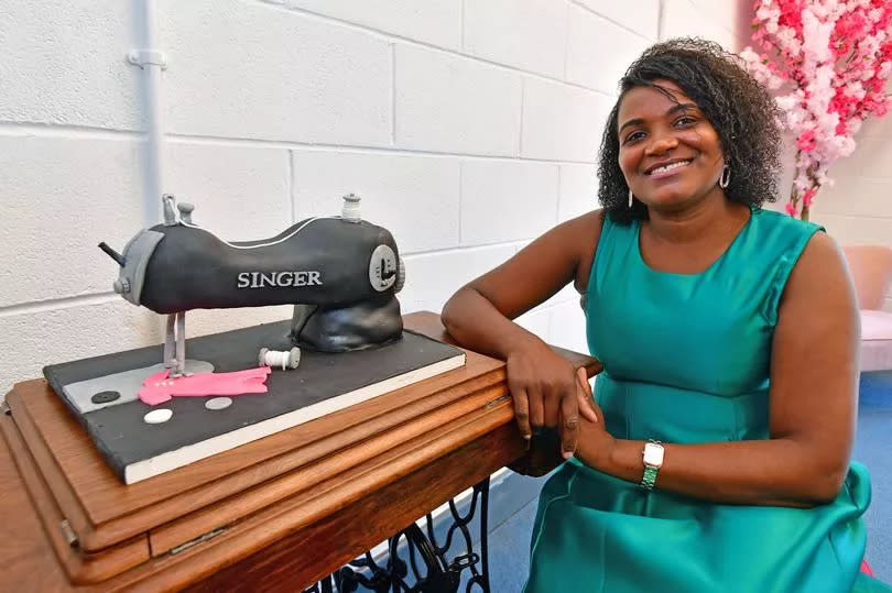 Isabel Lopes at her new clothes design shop on Upper Warwick Street in Toxteth with a cake made in the image of her Singer sewing machine that she refurbished. Photo by Colin Lane