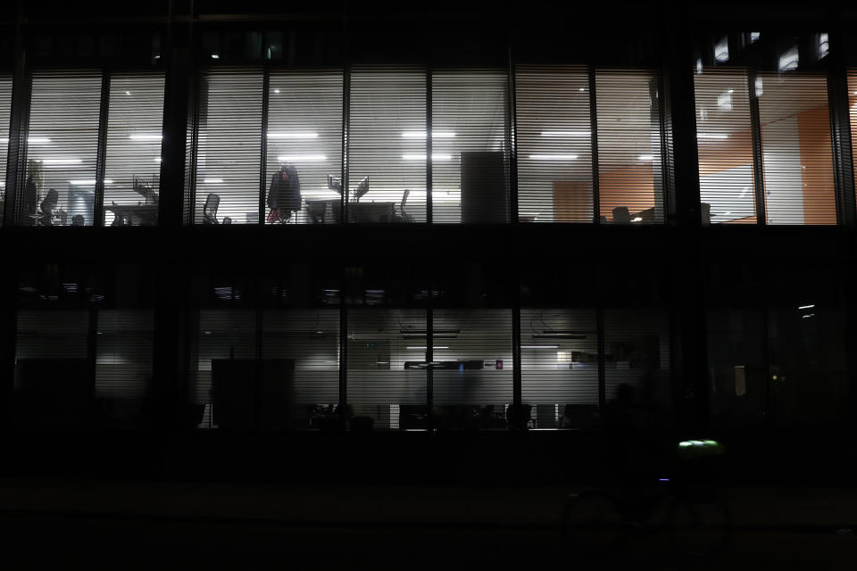 Lights shine from empty offices in the Barbican area of the City of London, Saturday, March 6, 2021. When the pandemic struck, about 540,000 workers vanished from London's financial hub almost overnight. The area known as "the City" became a ghost town as many people began working from home. A year on, most haven't returned to the business hub. (AP Photo/Alastair Grant)