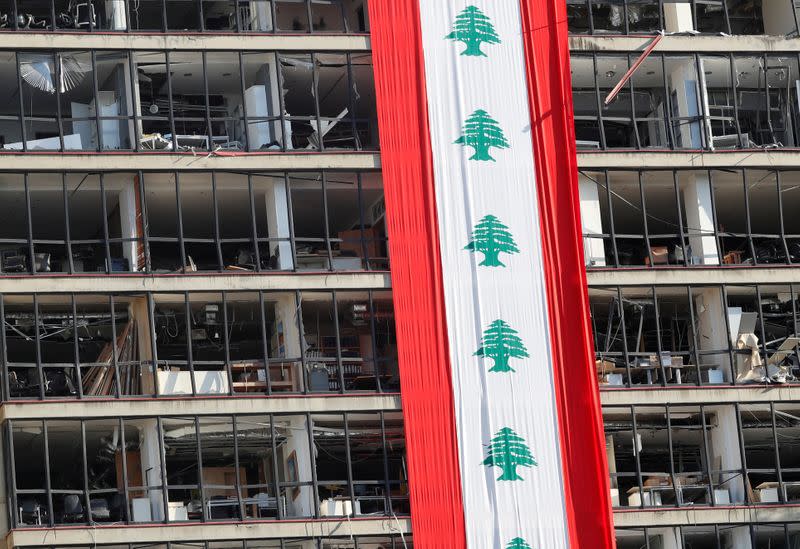 A big Lebanese flag is seen on a damaged building in Beirut