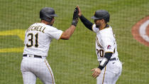 Pittsburgh Pirates' Cal Mitchell (31) and Joe Godoy head back to the dugout after scoring on an RBI double by Oneil Cruz off Cincinnati Reds starting pitcher Luis Cessa during the second inning of a baseball game in Pittsburgh, Wednesday, Sept. 28, 2022. (AP Photo/Gene J. Puskar)