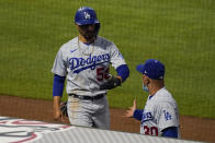 Los Angeles Dodgers' Mookie Betts (50) gets a high-five from manager Joe Maddon, right, after scoring off of a line drive hit by Justin Turner during the fifth inning of a baseball game Saturday, May 8, 2021, in Anaheim, Calif. (AP Photo/Ashley Landis)