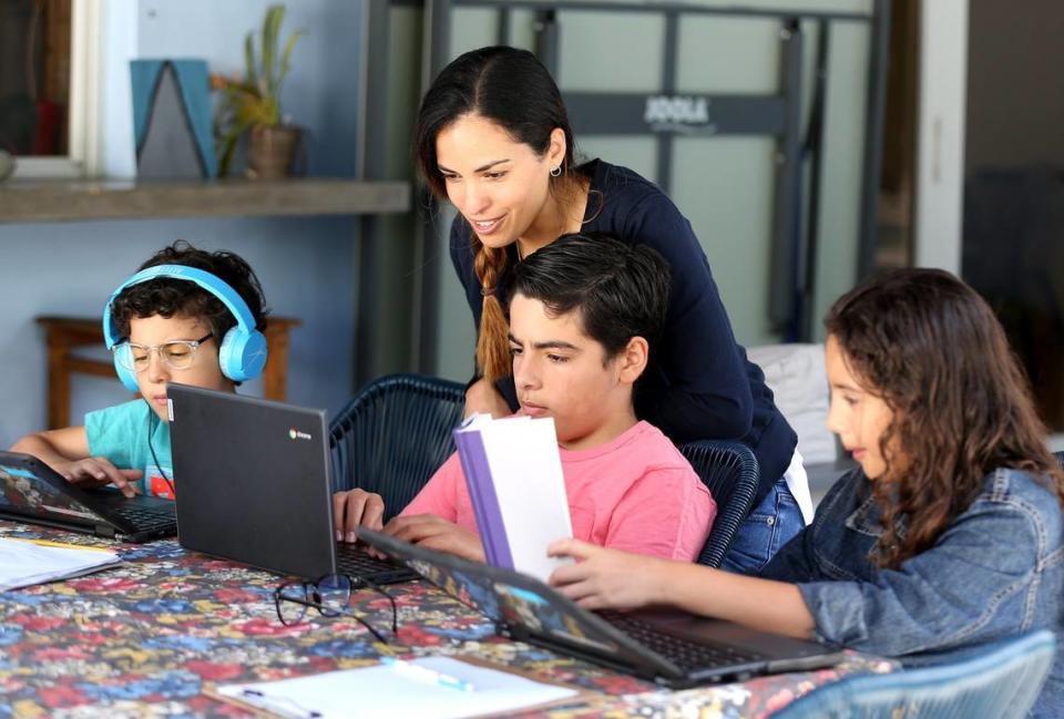 School teacher Maria Paola Attento works with her children, Gianmarco 1st grade, Sergio 6th grade, and Gianna 4th grade, in their North Miami home, May 7, 2020. Maria is a first-grade teacher at Aventura Charter School. She has been teaching her students through Zoom at home.