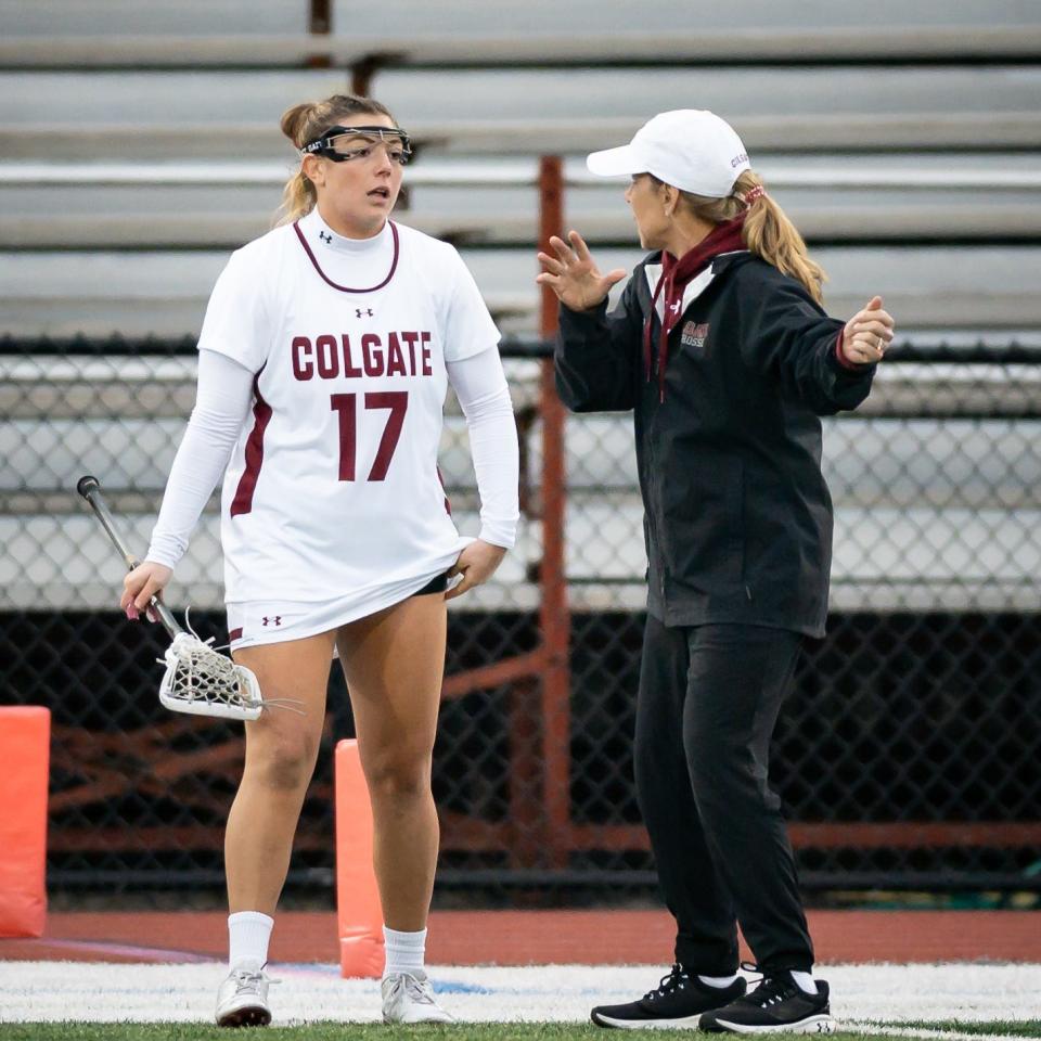 Colgate Women's Lacrosse Head Coach Kathy Taylor gives instructions to a player on the sideline during a home game at Colgate University.