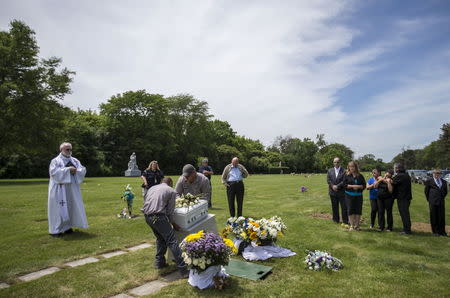 Workers prepare to move the casket of an abandoned newborn baby boy for burial at All Saints Cemetery in Des Plaines, Illinois, United States, June 19, 2015. REUTERS/Jim Young