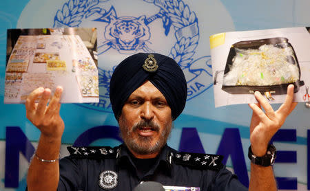 Commissioner Amar Singh, Malaysia's Federal Commercial Crime Investigation Department (CCID) director, displays photos of items from a raid during a news conference in Kuala Lumpur, Malaysia June 27, 2018. REUTERS/Lai Seng Sin