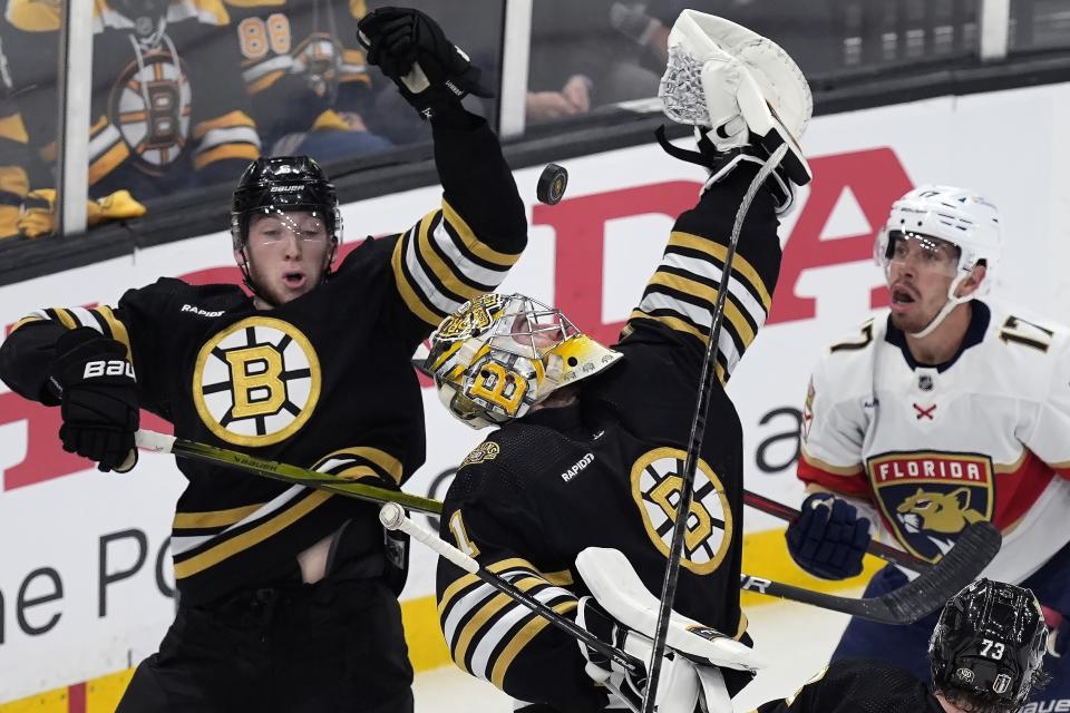Boston Bruins' Jeremy Swayman, center, tries to glove a loose puck alongside Bruins' Mason Lohrei (6) against Florida Panthers' Evan Rodrigues (17) during the first period in Game 4 of an NHL hockey Stanley Cup second-round playoff series, Sunday, May 12, 2024, in Boston. (AP Photo/Michael Dwyer)