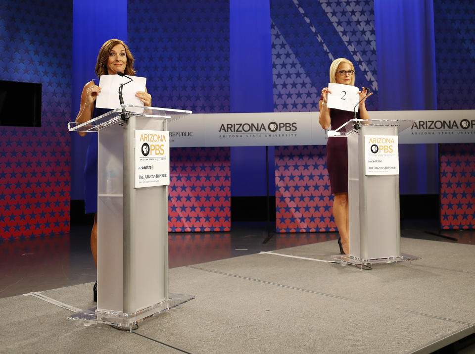 Sinema and McSally hold up signs showing their speaking order prior to a televised debate on Oct. 15, 2018, in Phoenix. (Photo: Matt York/AP)