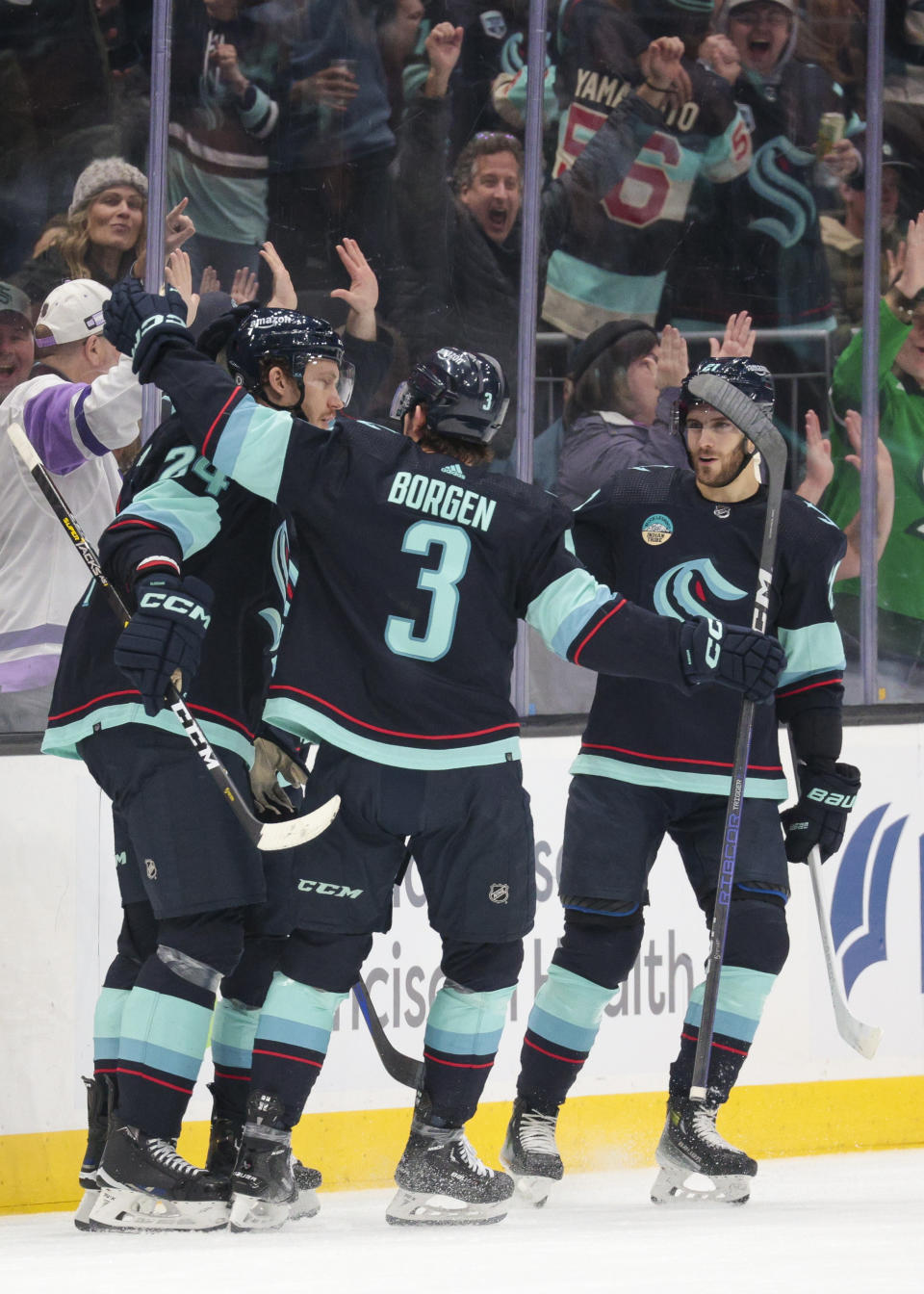 Seattle Kraken defenseman Jamie Oleksiak, left, celebrates his goal against the Tampa Bay Lightning with defenseman Will Borgen (3) and center Alex Wennberg (21) during the second period of an NHL hockey game Saturday, Dec. 9, 2023, in Seattle. (AP Photo/Jason Redmond)